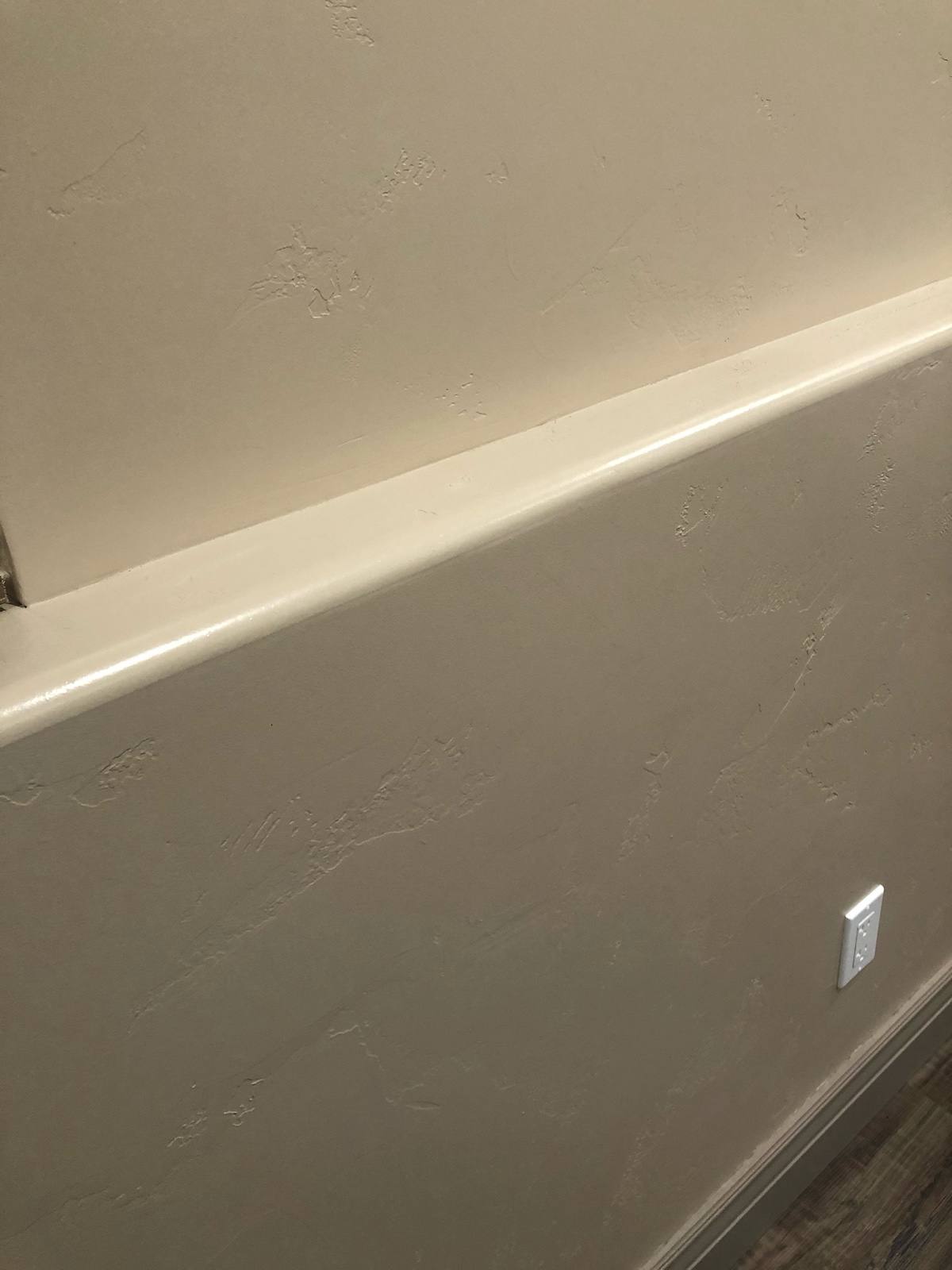 A crisp finished drywall edge where a textured wall meets the ceiling